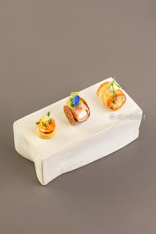 Elegant Canapé Appetizer Amuse Bouche food with salmon, caviar and ham in Michelin Star Restaurant